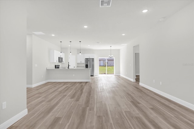 unfurnished living room with recessed lighting, visible vents, and baseboards