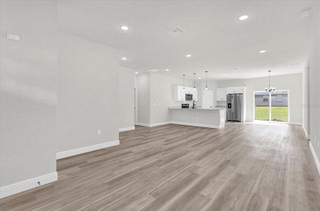 unfurnished living room with recessed lighting, light wood-type flooring, visible vents, and baseboards