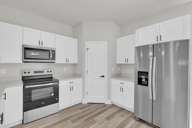 kitchen with light wood-style flooring, light countertops, white cabinetry, and stainless steel appliances