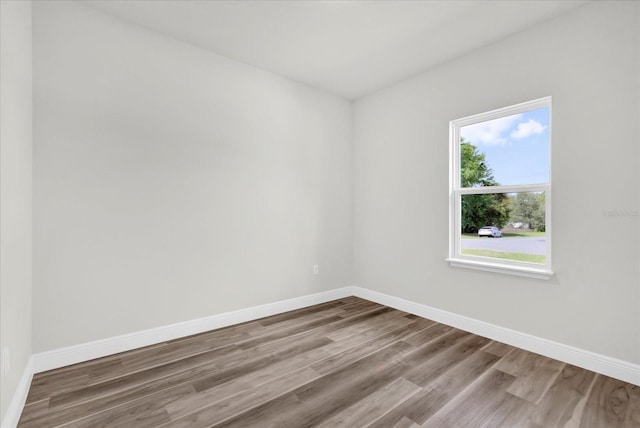 empty room featuring baseboards and wood finished floors