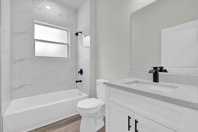bathroom featuring washtub / shower combination, vanity, toilet, and wood finished floors