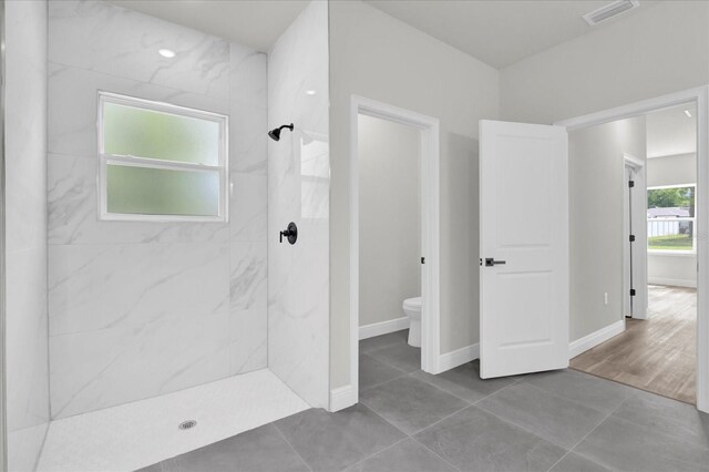 bathroom featuring a marble finish shower, visible vents, toilet, and tile patterned flooring
