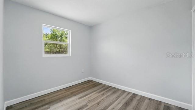 empty room featuring wood finished floors and baseboards