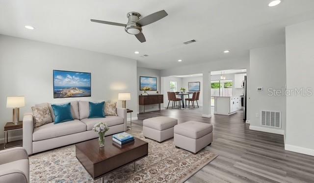 living room with a ceiling fan, wood finished floors, baseboards, visible vents, and recessed lighting
