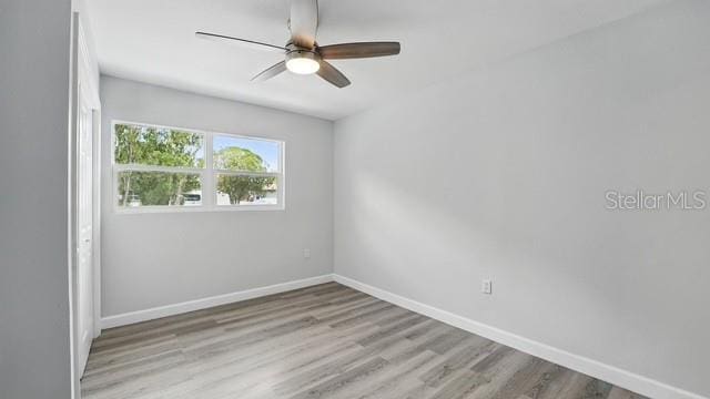 unfurnished room featuring baseboards, a ceiling fan, and wood finished floors