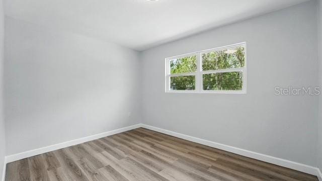 empty room featuring baseboards and wood finished floors