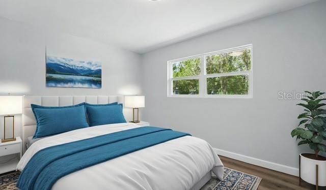 bedroom featuring wood finished floors and baseboards