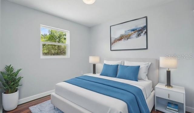 bedroom with baseboards and wood finished floors