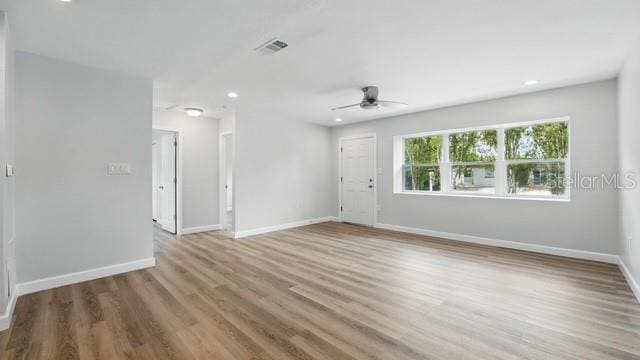 spare room with recessed lighting, wood finished floors, visible vents, a ceiling fan, and baseboards
