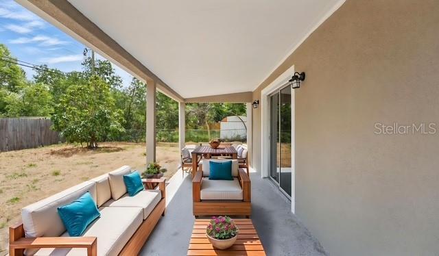view of patio featuring an outdoor hangout area and fence