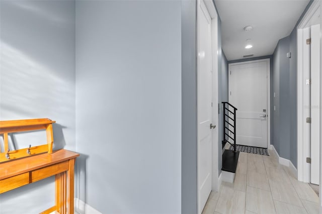 corridor with light tile patterned floors, baseboards, and visible vents