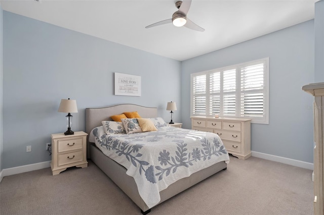 bedroom featuring light colored carpet, baseboards, and a ceiling fan