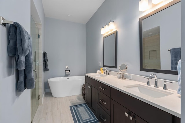 full bath featuring a sink, a freestanding bath, a stall shower, and double vanity