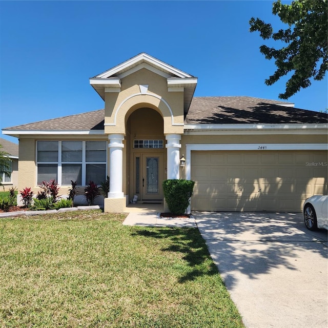 view of front of house featuring a garage, stucco siding, a front yard, a shingled roof, and concrete driveway