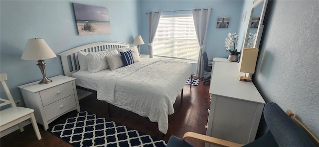 bedroom with a textured wall and wood finished floors