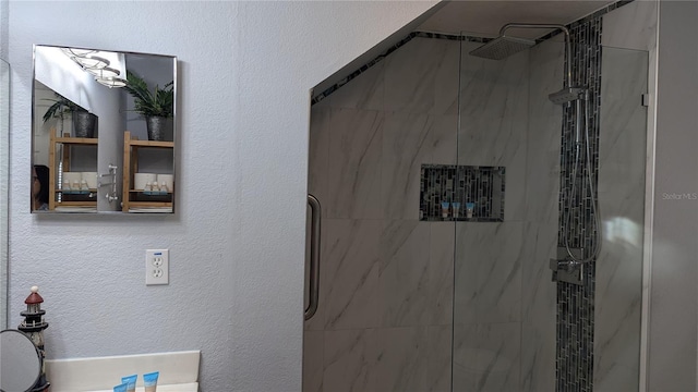 bathroom with a textured wall, a sink, and a marble finish shower