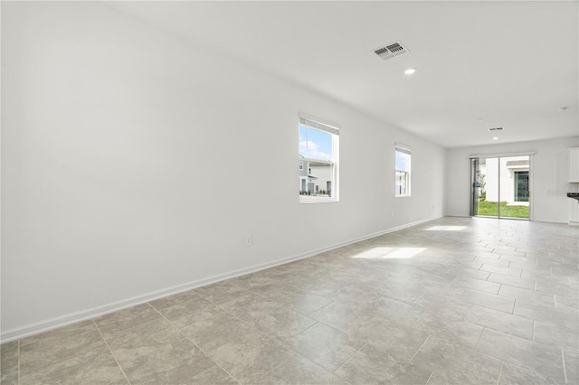 unfurnished room with recessed lighting, visible vents, and baseboards