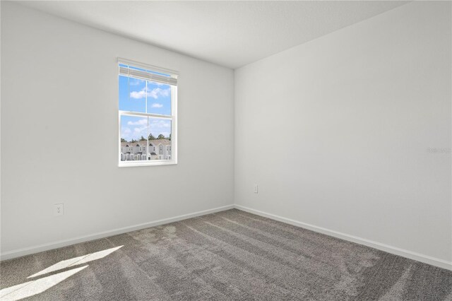 unfurnished room featuring baseboards and carpet flooring
