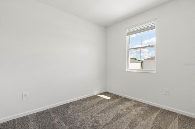 empty room with baseboards and carpet flooring