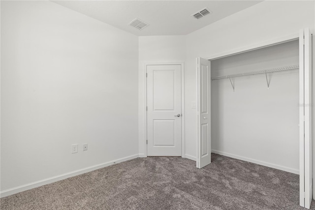 unfurnished bedroom with a closet, carpet flooring, visible vents, and baseboards