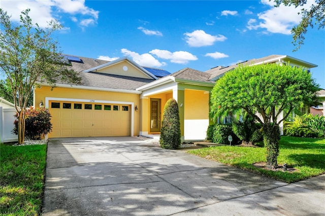 view of front facade with concrete driveway, stucco siding, an attached garage, and roof mounted solar panels
