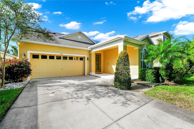 view of front facade featuring a garage, stucco siding, and driveway