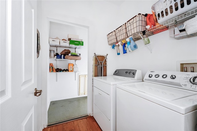 washroom with light wood-style floors, laundry area, and washing machine and clothes dryer
