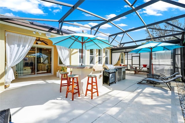 view of patio featuring ceiling fan, a grill, outdoor dry bar, and glass enclosure