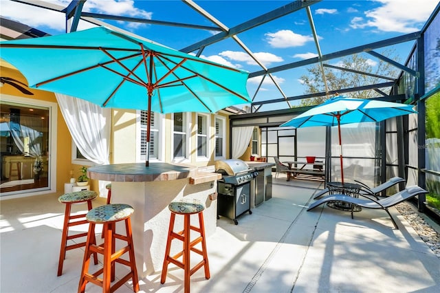 view of patio / terrace with a lanai, grilling area, and outdoor dry bar