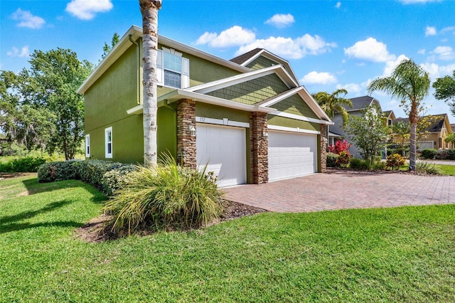 view of side of home with a yard, an attached garage, stucco siding, and decorative driveway