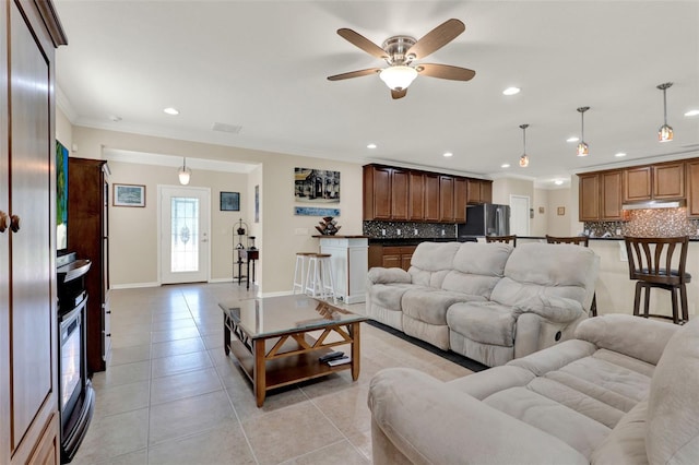 living room with light tile patterned floors, ornamental molding, and recessed lighting