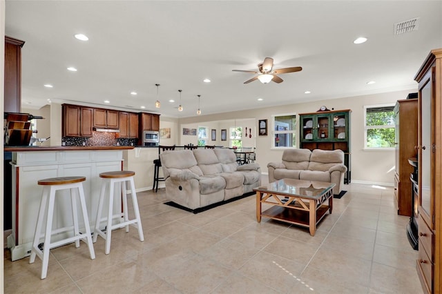 living area with recessed lighting, visible vents, a ceiling fan, light tile patterned floors, and crown molding