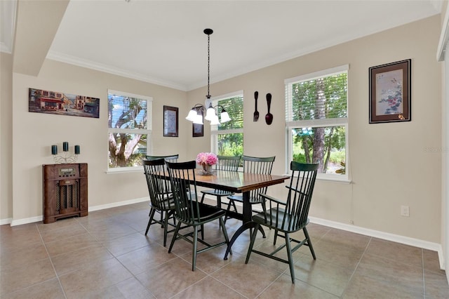 dining room with ornamental molding, baseboards, a notable chandelier, and light tile patterned floors