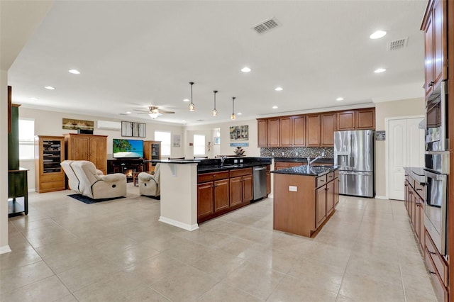 kitchen featuring ceiling fan, visible vents, open floor plan, and stainless steel appliances