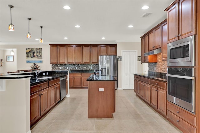 kitchen with visible vents, ornamental molding, a sink, a center island with sink, and appliances with stainless steel finishes
