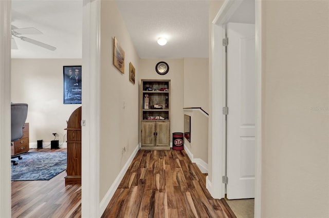 hall featuring baseboards and dark wood-style flooring