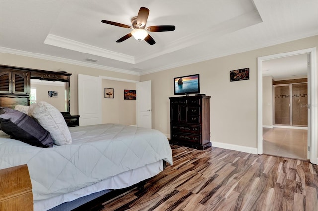 bedroom featuring visible vents, a ceiling fan, wood finished floors, crown molding, and a raised ceiling
