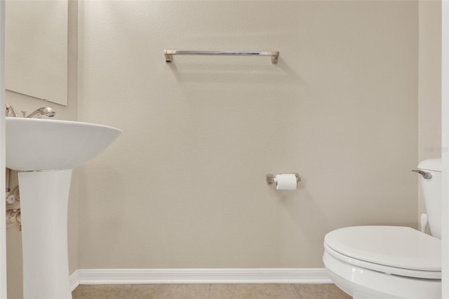 bathroom featuring tile patterned floors, baseboards, and toilet