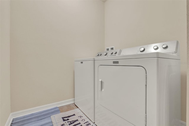 laundry room with washing machine and clothes dryer, laundry area, and baseboards
