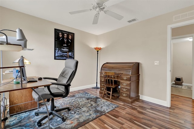 office with baseboards, a ceiling fan, wood finished floors, and visible vents