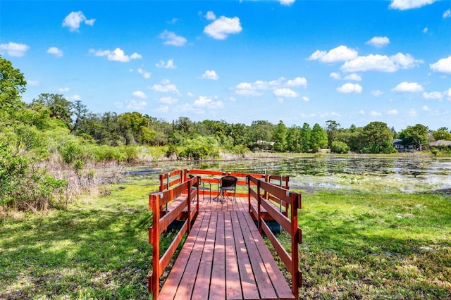 wooden deck featuring a forest view and a water view