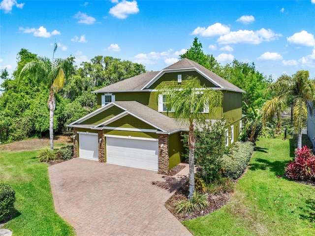 craftsman-style house with decorative driveway, stone siding, a shingled roof, an attached garage, and a front yard