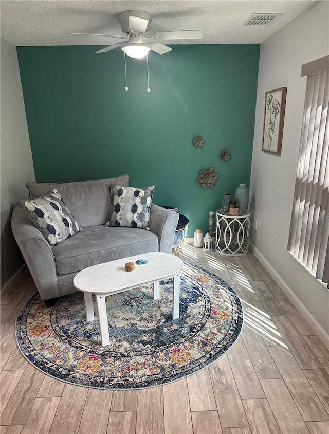 4800 S Semoran Blvd Unit 101, Orlando, FL 32822 - living room featuring wood finished floors, a ceiling fan, baseboards, and a textured ceiling