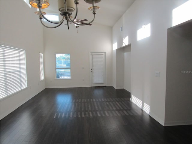 interior space featuring a chandelier, wood finished floors, a high ceiling, and baseboards