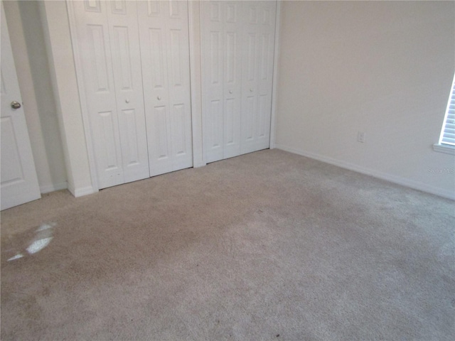 unfurnished bedroom featuring carpet floors, a closet, and baseboards