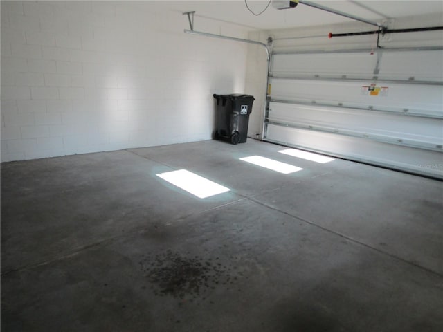 garage with concrete block wall and a garage door opener