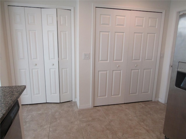 interior space featuring baseboards and light tile patterned flooring