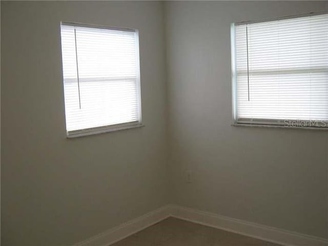 spare room with baseboards