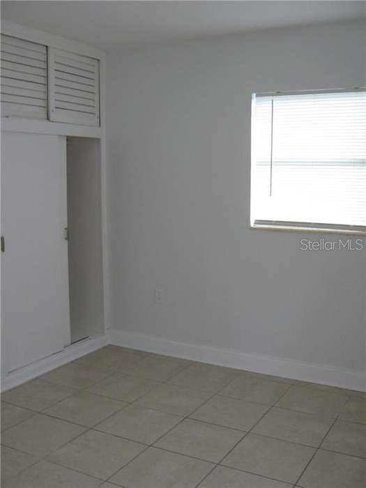 empty room featuring light tile patterned floors and baseboards