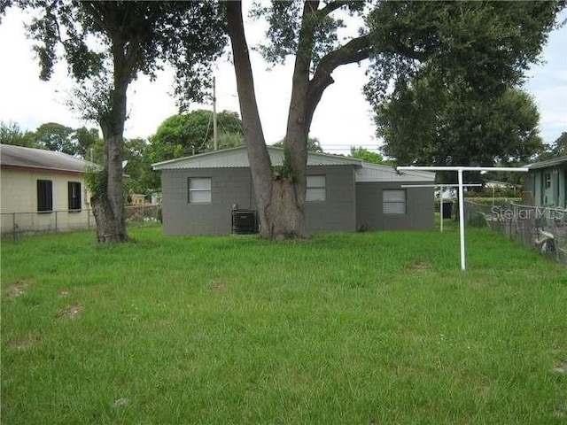 view of yard featuring fence and central AC
